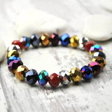 Multi-colour metallic beads bracelet on wooden surface