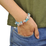 Woman wearing a multi-coloured candy pastel bracelet with blue and white crystals