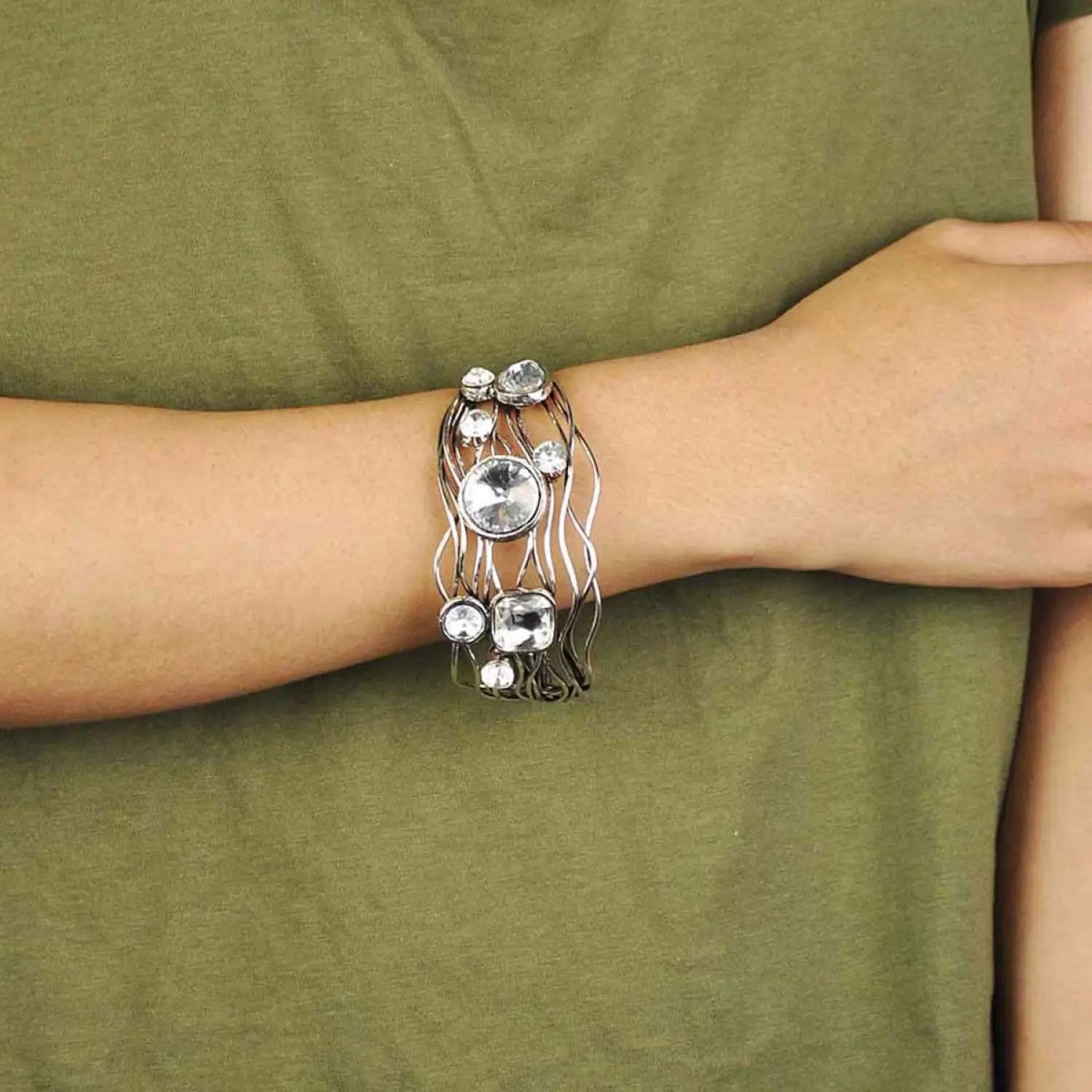 Woman wearing multi-layered statement bracelet with silver ring accent.