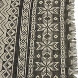 Oversized Aztec pattern shawl scarf with black and white fringed rug