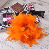 Oversized Feather Hair Scrunchie with small orange feather on chocolate bar