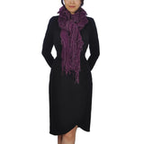 Woman wearing black dress & purple scarf, showcasing oversized netted lurex knitted scarf with tassels.