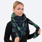 Oversized tartan check winter blanket poncho with woman wearing green and black plaid scarf
