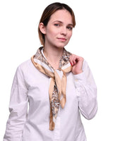 White shirt woman wearing beige paisley satin square scarf.