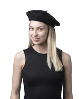 ’Woman smiling in black Parisian beret with pearl embellishment’