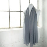 Pearl chiffon scarf hanging on white wall