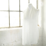 White chiffon scarf with durable pearl attachments hanging on window side