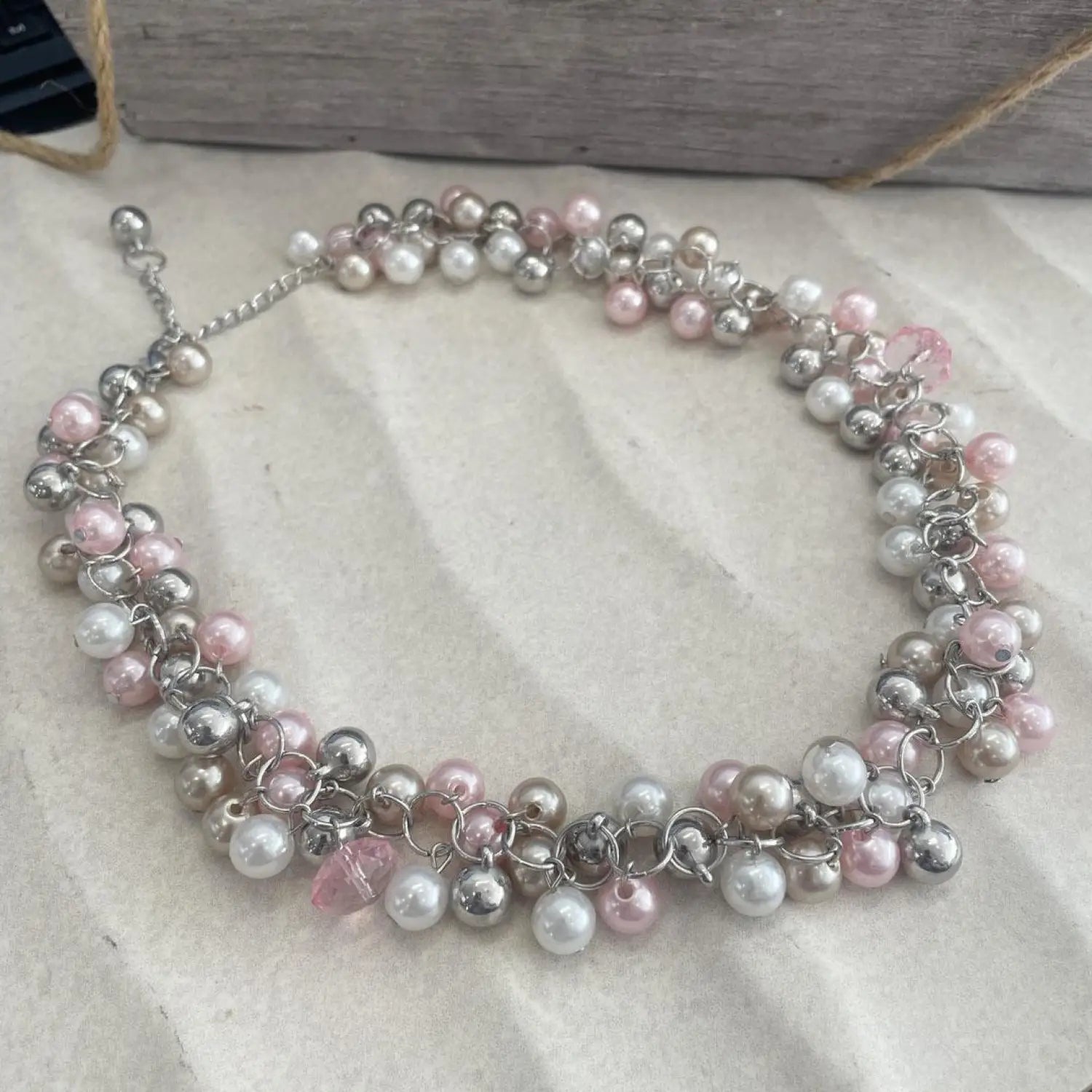Pink Pearl Cluster Bib Necklace featuring a pink and silver bracelet with pearls