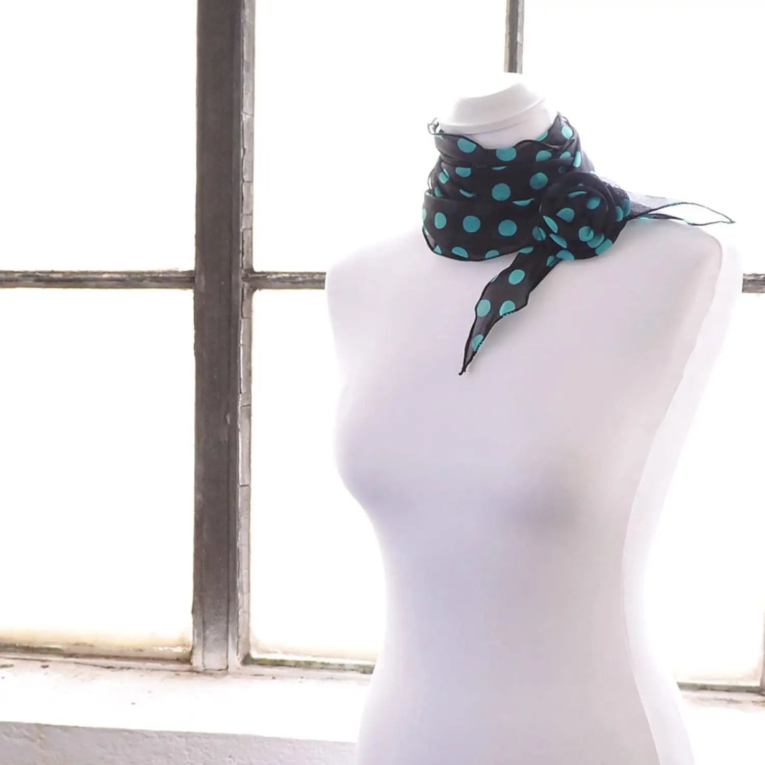 Polka dot chiffon mannequin wearing blue and green polka print scarf and flower hair clips from set