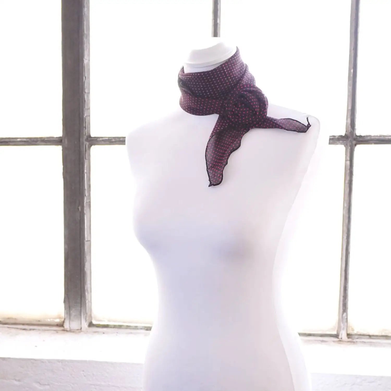 Polka dot chiffon scarf with purple and black polka print scarf on mannequin