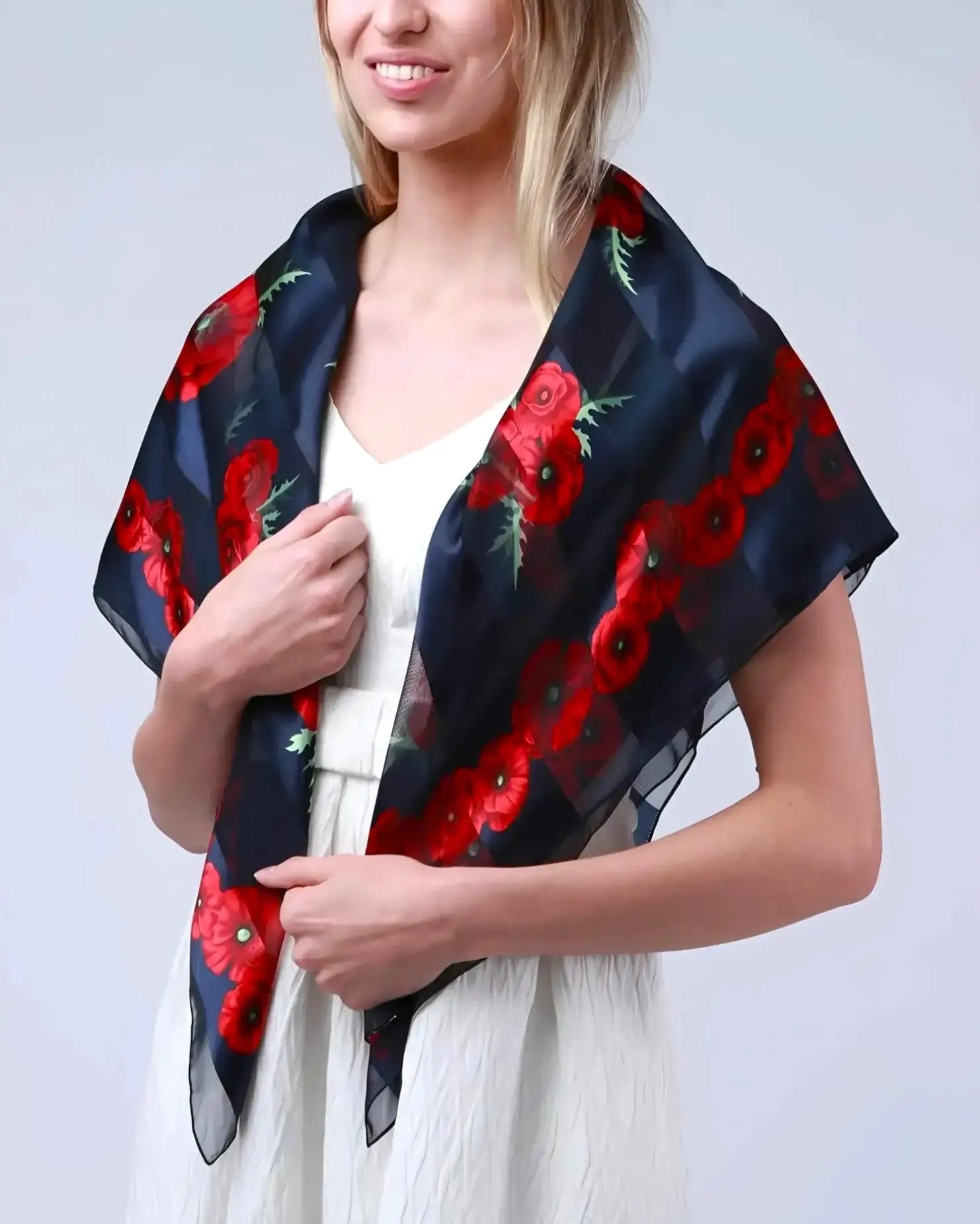 Large square poppy scarf in black and red floral print worn by woman.