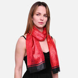 Woman wearing rose print scarf with black border and satin stripe finish.