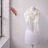 Lightweight knitted ruffled white scarf with fringes on mannequin