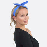 Woman wearing blue satin wired bunny ears headband.