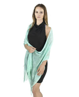 Woman wearing green shimmering lurex fishnet scarf.