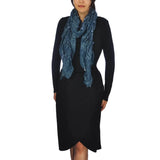 Woman wearing a black dress and blue scarf with shimmering metallic textured ruffled scarf.