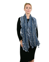 Soft knitted scarf with ruffled texture and striped print on a woman