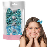 Girl with hands on face holding bag of glitter next to Sparkling Bow Rhinestone Hair Clips Set