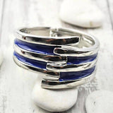 Blue enamel rings stack on white rock, Striped Metal Hinged Bangle Vintage-Inspired Bracelet.