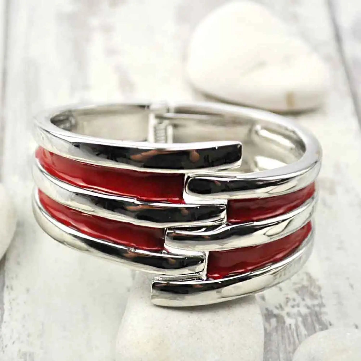 Vintage-inspired red and silver heart ring on striped metal hinged bangle