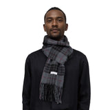 Tartan winter scarf with fringe wrapped around a person’s neck, soft and warm feel