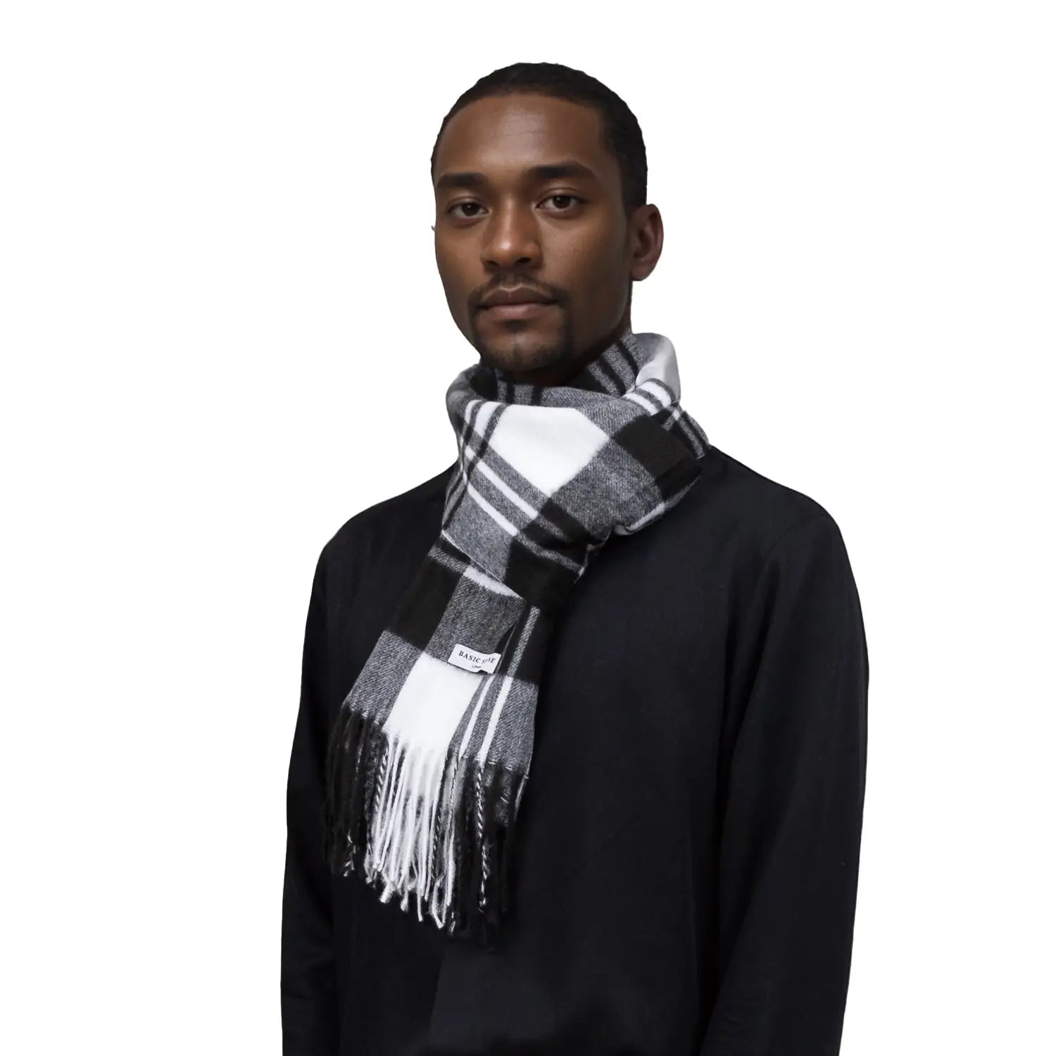 Man in a black sweater and plaid fringe scarf featuring a soft tartan winter design