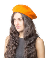 French wool beret in elegant orange hat worn by woman