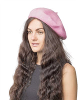 Woman with long brown hair wearing a pink wool beret