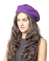 Stylish woman in purple hat and black dress wearing French wool beret