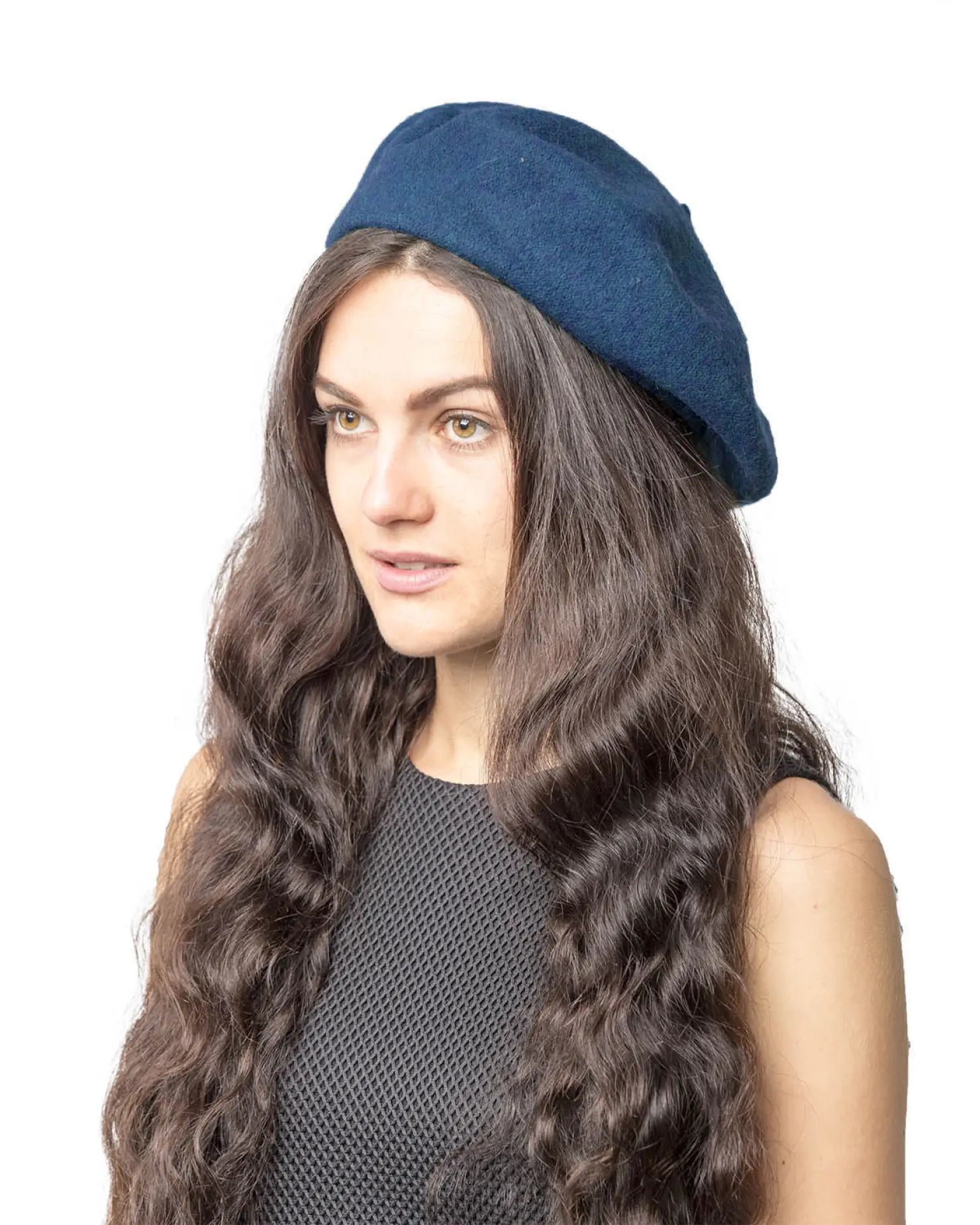 Woman with long brown hair wearing a blue French wool beret