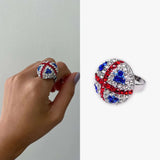 Woman’s hand holding Union Jack Sparkling ring with red, white, blue diamonds