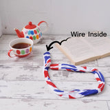 Union Jack wire headband with book and teapot on table.