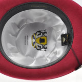 Red wool felt bowler hat with black and yellow emblem.