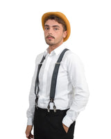 Stylish unisex individual in bowler hat and suspenders posing