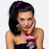Woman wearing a flower hair accessory from the Velvet Skinny Hair Scrunchies Set.