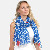 Woman wearing blue and white oversized heart print scarf from Vibrant Oversized Heart Print Scarf Wrap.