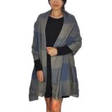 Oversized checked blanket scarf in grey and blue worn by woman