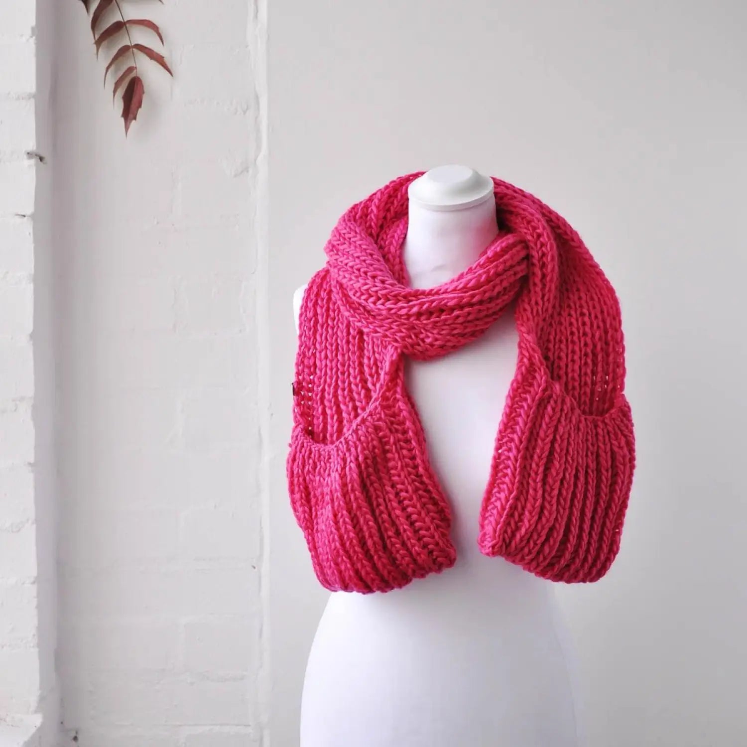 Pink knitted scarf on mannequin for Winter Chunky Knitted Scarf with Pockets.
