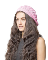 Woman with long brown hair wearing pink cable knit crochet beanie hat.