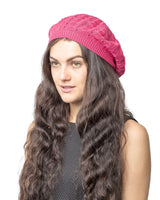 Woman wearing pink cable design knitted crochet beanie hat.