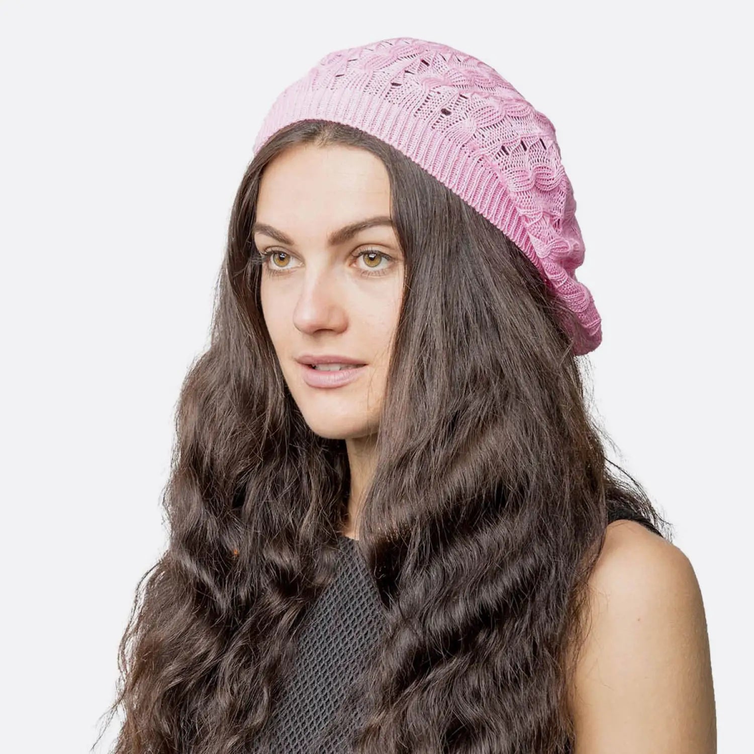 Woman wearing pink cable design knitted crochet beanie hat