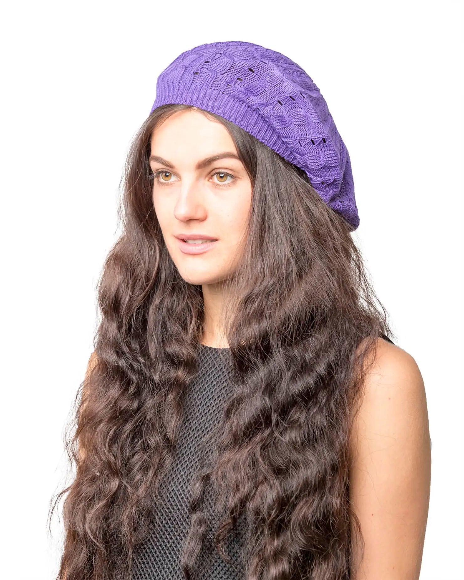 Woman wearing purple cable design knitted crochet beanie hat